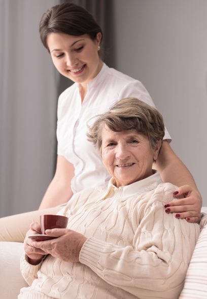 Young female caregiver taking care of older woman